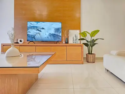 a living room with a tv on a wooden cabinet at Fahrenheit #185 Kuala Lumpur Bukit Bintang in Kuala Lumpur