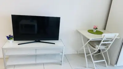 a television sitting on a white stand next to a table at Summer Suites by Western Holiday in Kuala Lumpur