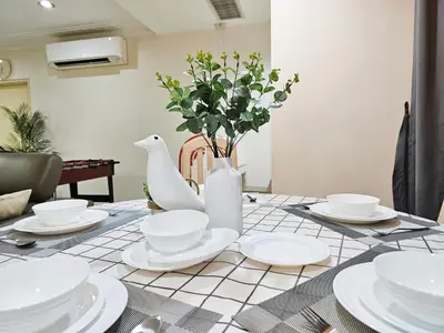 a table with white dishes and a vase with flowers at Bukit Bintang Fahrenheit #113 KLCC Kuala Lumpur in Kuala Lumpur