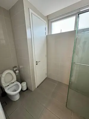 a bathroom with a toilet and a glass shower at Cosy 2-bedroom KLCC in Kuala Lumpur