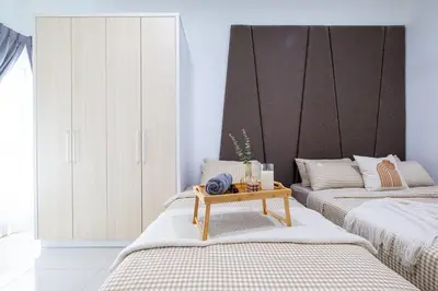 two beds in a room with a table between them at RC Residence By Feel Home in Kuala Lumpur