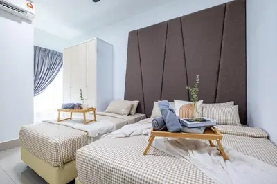 a bedroom with two beds and a table with a laptop at RC Residence By Feel Home in Kuala Lumpur