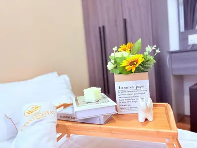 a table with books and a vase of flowers on it at Perfect for Families & Larger Groups, KL MRT- M Vertica in Kuala Lumpur