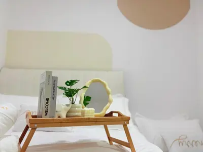 a wooden tray with books and plants on a bed at Perfect for Families & Larger Groups, KL MRT- M Vertica in Kuala Lumpur