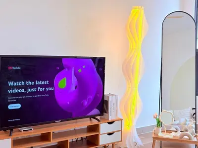 a flat screen tv sitting on top of a wooden entertainment center at Perfect for Families & Larger Groups, KL MRT- M Vertica in Kuala Lumpur