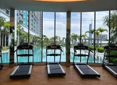a gym with a pool in a building with glass windows at trion kl one bedroom studio in Kuala Lumpur