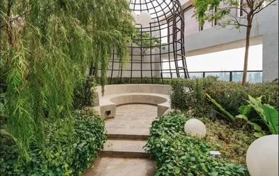 a garden with a bench in front of a building at trion kl one bedroom studio in Kuala Lumpur