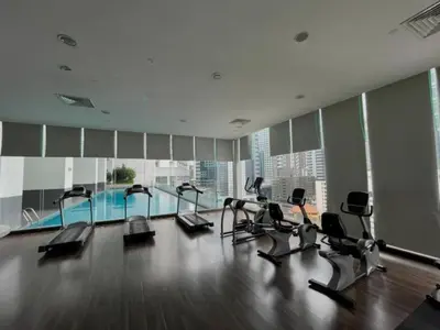 a gym with several treadmills and a swimming pool at 1Bukit ceylon view 118 in Kuala Lumpur