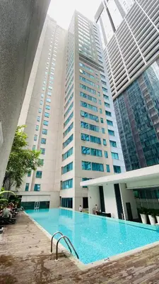 a large building with a swimming pool in front of it at Mercu Summer Suites near KLCC in Kuala Lumpur