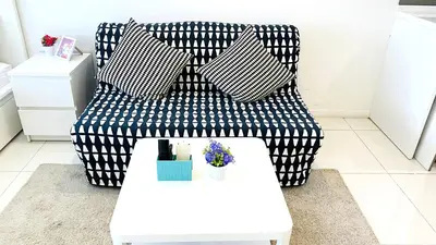 a living room with a black and white couch and a table at Mercu Summer Suites near KLCC in Kuala Lumpur