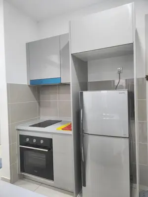 a kitchen with a refrigerator and a stove at TRION Grand Service Suites at KL in Kuala Lumpur