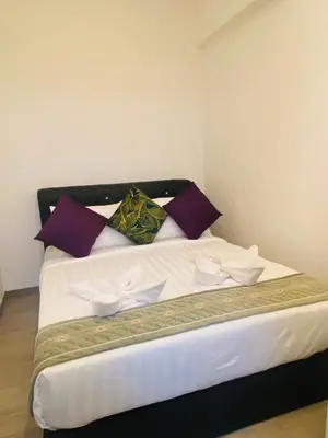 a bedroom with a large bed with purple pillows at AGILE Galaxy Suite in Kuala Lumpur