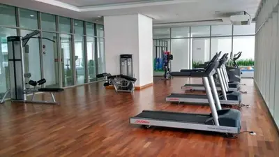 a gym with several treadmills and machines in a room at KL Gateway Residence Bangsar by The Luxe in Kuala Lumpur