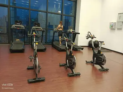 a woman exercising on exercise bikes in a gym at Starlight Suite At Chambers Kuala Lumpur KLCC in Kuala Lumpur