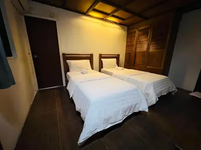 two beds in a room with white sheets at Iviillainn in Kuala Lumpur