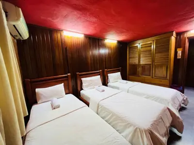 three beds in a room with red walls at Iviillainn in Kuala Lumpur