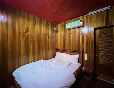 a bed in a room with a wooden wall at Iviillainn in Kuala Lumpur