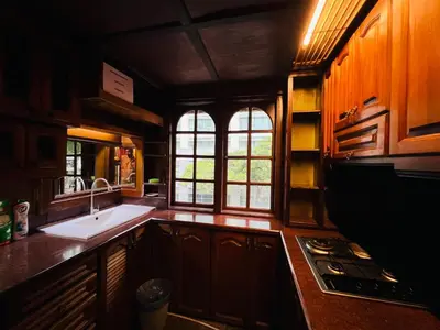 a kitchen with a sink and a stove and windows at Iviillainn in Kuala Lumpur