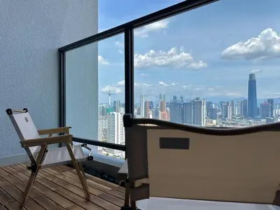 a chair on a balcony with a view of a city at 9 Pax 3R3B Trion KL City View 10Mins to KLCC in Kuala Lumpur