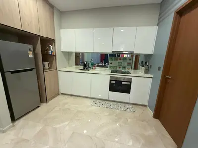 a kitchen with white cabinets and a tile floor at Sky Premium suites klcc in Kuala Lumpur