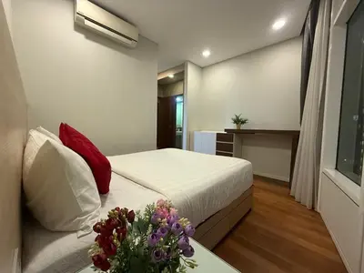 a bedroom with a bed and a vase of flowers on a table at Sky Premium suites klcc in Kuala Lumpur