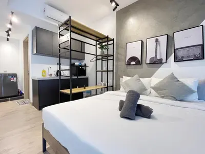 a bedroom with a large white bed and a kitchen at The colony by Klcc view sweet home in Kuala Lumpur