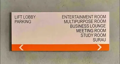 an orange and white sign hanging on a wall at Private Room Queen Size KLCC in Kuala Lumpur