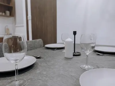 a table with wine glasses and plates on it at Cozy Kenwingston Platz KL 2-5 Pax 2BR & 2BR FrePakin Netflix 2802 in Kuala Lumpur
