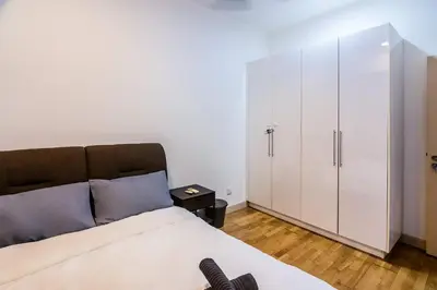 a bedroom with a large bed and a white cabinet at Chic High-Floor 3BR Apt in Bukit Bintang in Kuala Lumpur
