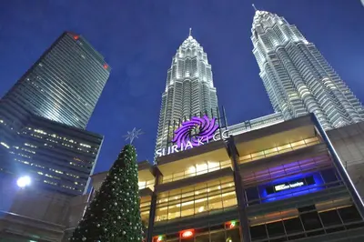 a christmas tree in front of a building with tall buildings at Chic High-Floor 3BR Apt in Bukit Bintang in Kuala Lumpur