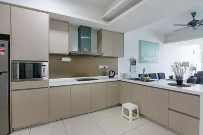 a kitchen with white and brown cabinets and a refrigerator at Chic High-Floor 3BR Apt in Bukit Bintang in Kuala Lumpur