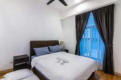 a bedroom with a bed and a large window at Chic High-Floor 3BR Apt in Bukit Bintang in Kuala Lumpur