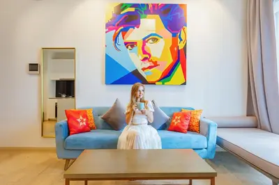 a woman sitting on a blue couch in a living room at Star Deluxe Suites KLCC by WSD in Kuala Lumpur