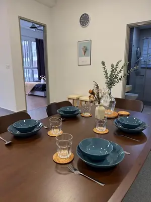a wooden table with blue plates and glasses on it at Sentrio Pandan Kuala Lumpur KLCC KL Tower TRX 10 in Kuala Lumpur