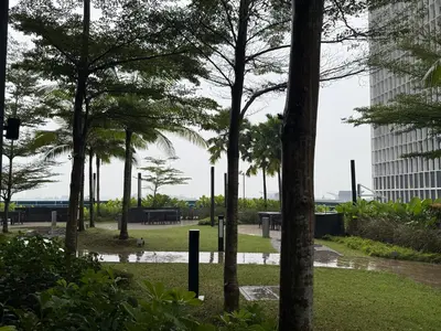 a park with palm trees and a building at Eaton Premier Suite KLCC in Kuala Lumpur