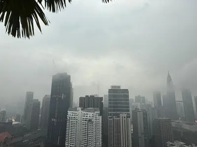a city skyline on a foggy day with tall buildings at Eaton Premier Suite KLCC in Kuala Lumpur