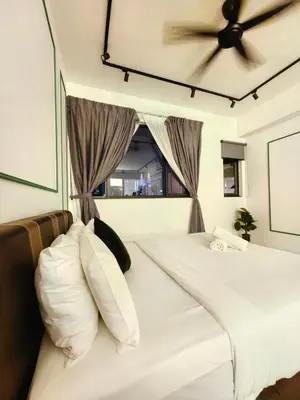 a bed with white pillows and a ceiling fan at Chamber Resident Service KLCC in Kuala Lumpur