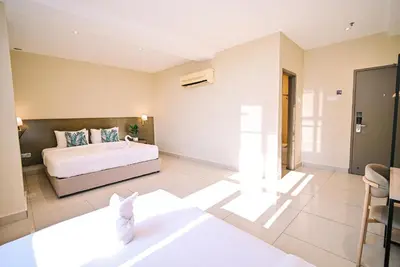 a bedroom with a bed and a table and chairs at Kingston Hotel 12 - Jalan Raja Laut, KL in Kuala Lumpur