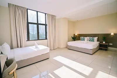 a bedroom with two beds and a large window at Kingston Hotel 12 - Jalan Raja Laut, KL in Kuala Lumpur