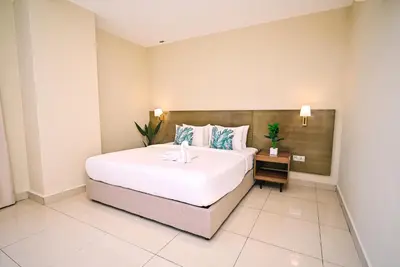 a bedroom with a large white bed and a table at Kingston Hotel 12 - Jalan Raja Laut, KL in Kuala Lumpur