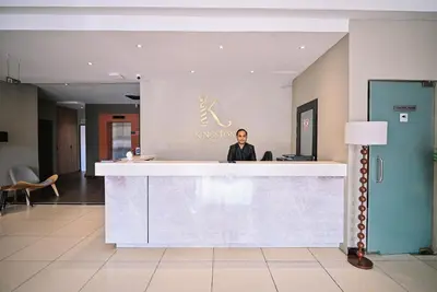 a man standing behind a counter in a lobby at Kingston Hotel 12 - Jalan Raja Laut, KL in Kuala Lumpur