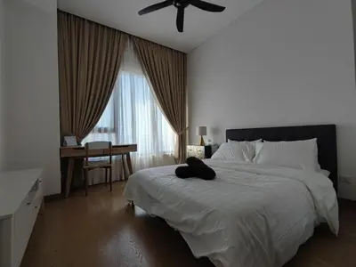 a bedroom with a bed with a ceiling fan and a desk at Lucentia Residences in Kuala Lumpur