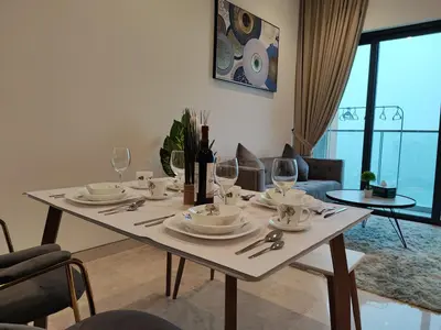 a table with plates and wine glasses in a living room at Lucentia Residences in Kuala Lumpur