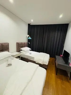 a bedroom with two beds and a desk with a laptop at URBAN COZY HOME at SkySuites Near KLCC Complimentary Breakfast in Kuala Lumpur