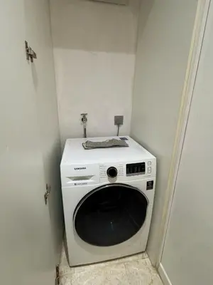 a washing machine in a corner of a room at URBAN COZY HOME at SkySuites Near KLCC Complimentary Breakfast in Kuala Lumpur