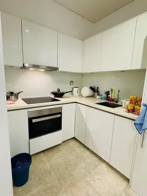 a small kitchen with white cabinets and a sink at URBAN COZY HOME at SkySuites Near KLCC Complimentary Breakfast in Kuala Lumpur