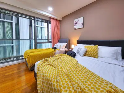 a room with two beds with yellow sheets and a window at Bukit Bintang Fairlane Residence Kuala Lumpur #1510 in Kuala Lumpur