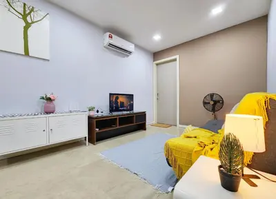a bedroom with a yellow bed and a flat screen tv at Bukit Bintang Fairlane Residence Kuala Lumpur #1510 in Kuala Lumpur
