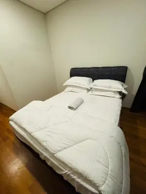 a white bed with a remote control on top of it at URBAN COMFY HOME at SkySuites Near KLCC Complimentary Breakfast in Kuala Lumpur