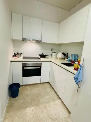 a small kitchen with white cabinets and a stove at URBAN COMFY HOME at SkySuites Near KLCC Complimentary Breakfast in Kuala Lumpur